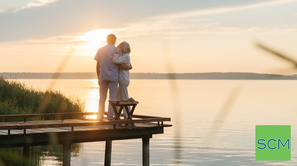 Older couple watching sunset from dock