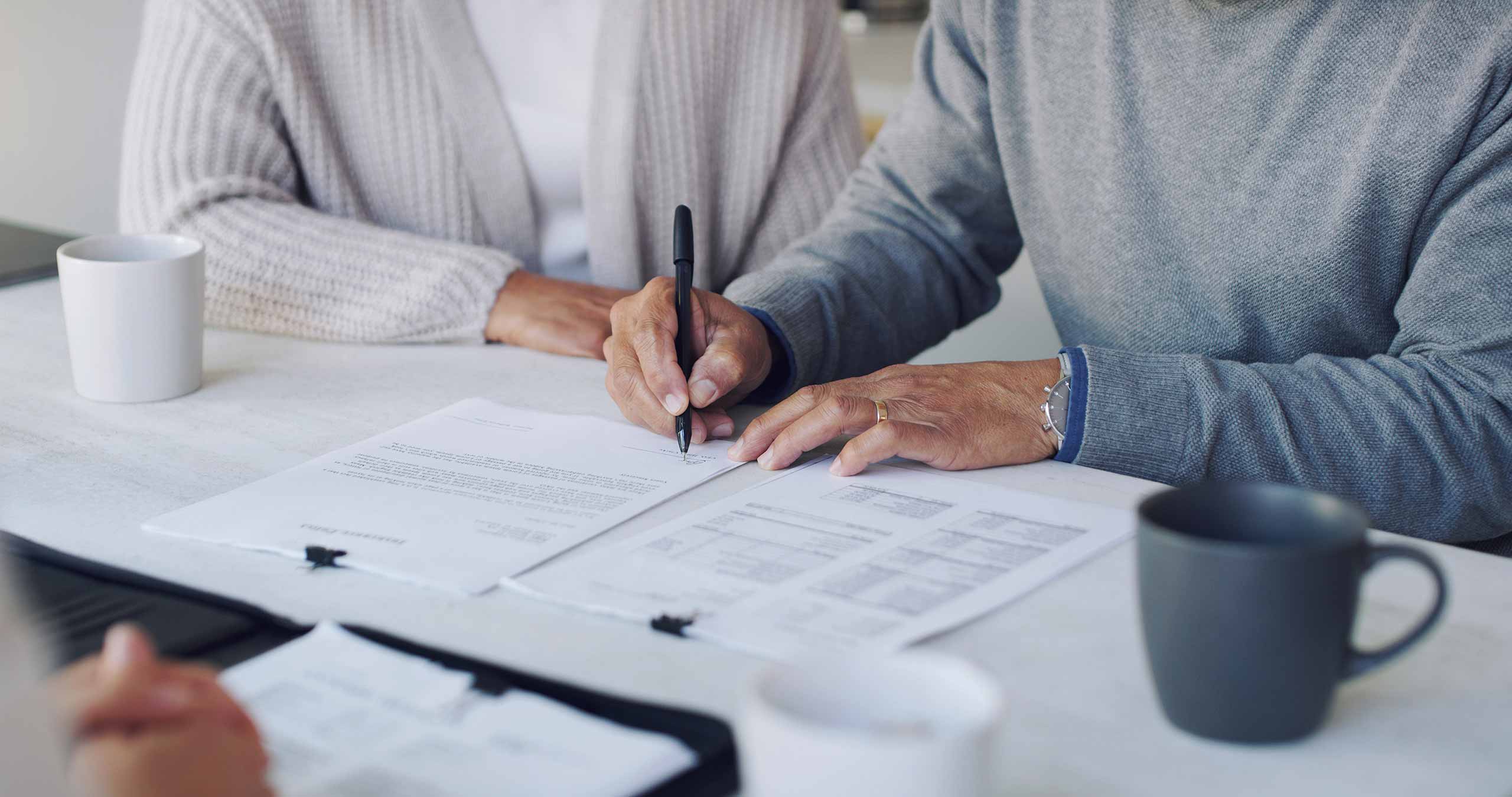 Couple signing on 401k plan documents with finance advisor