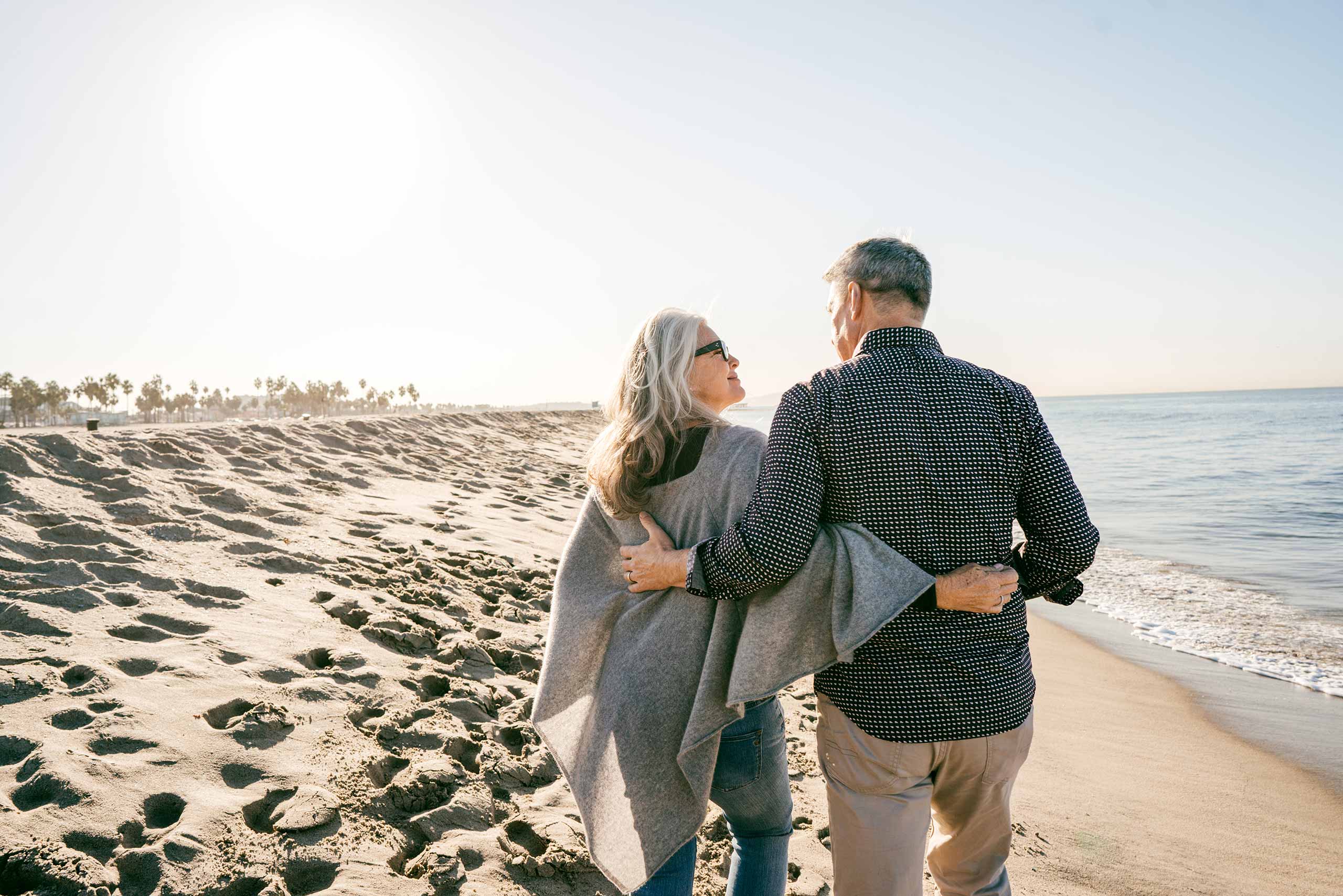 Retired couple walking on beach