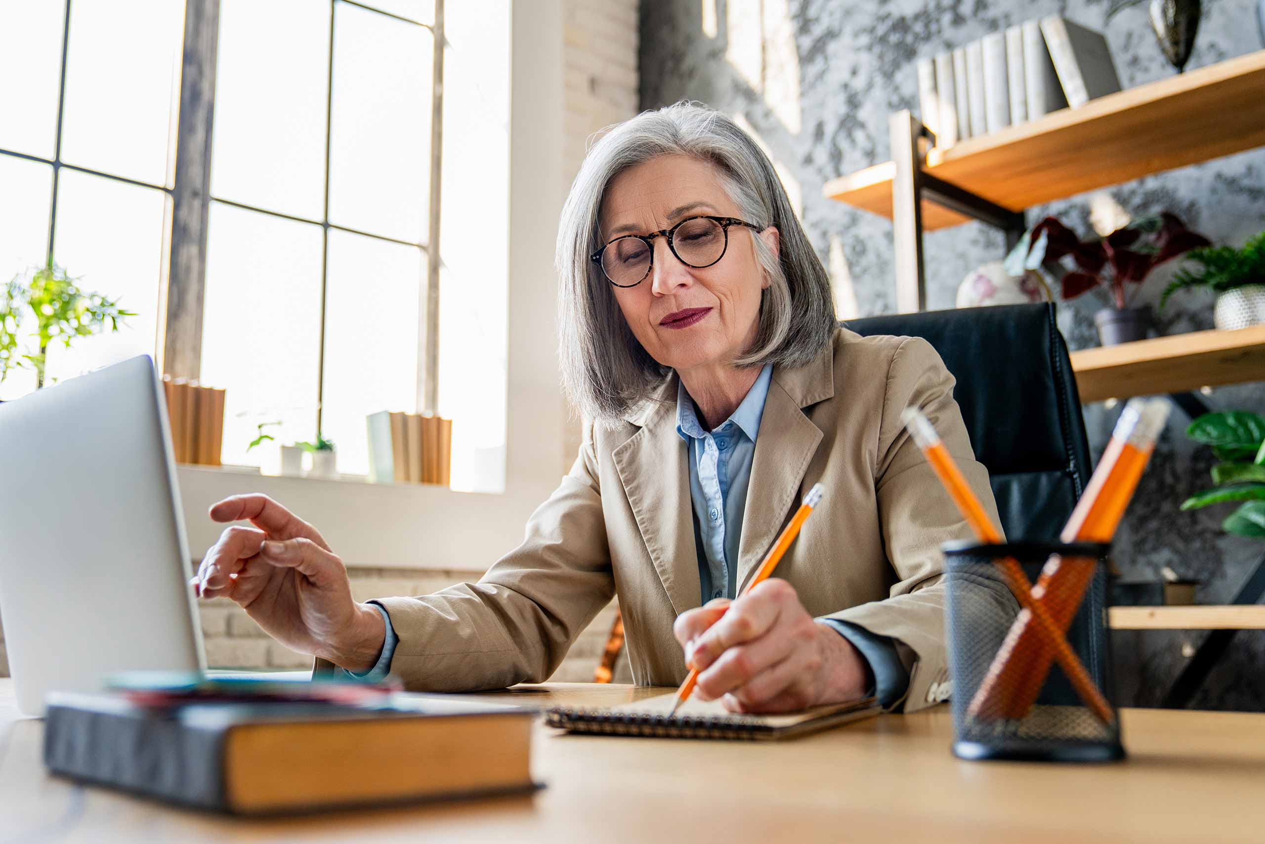 Business woman working on pension analysis finances with laptop