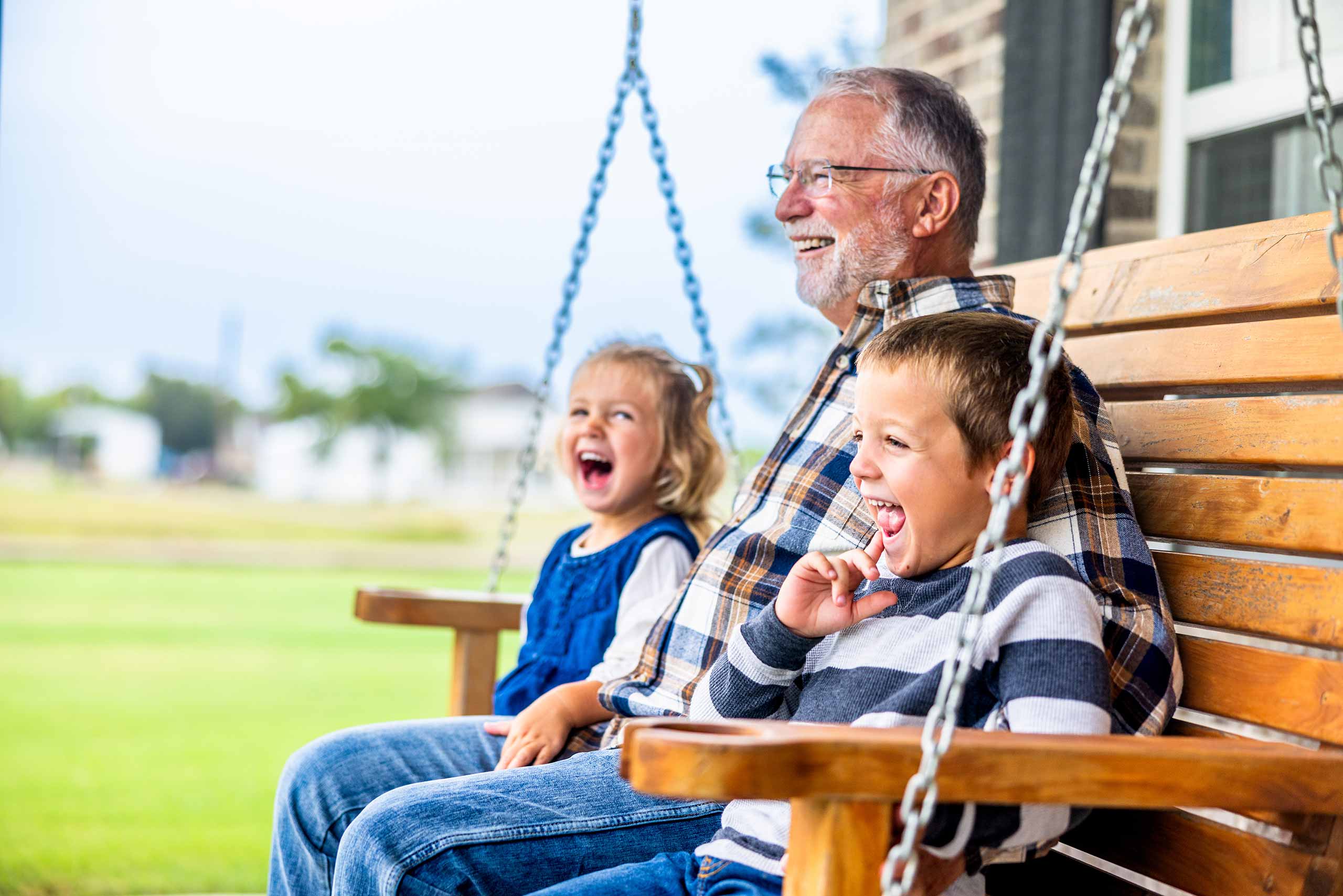 Grandfather with kids on porch swing