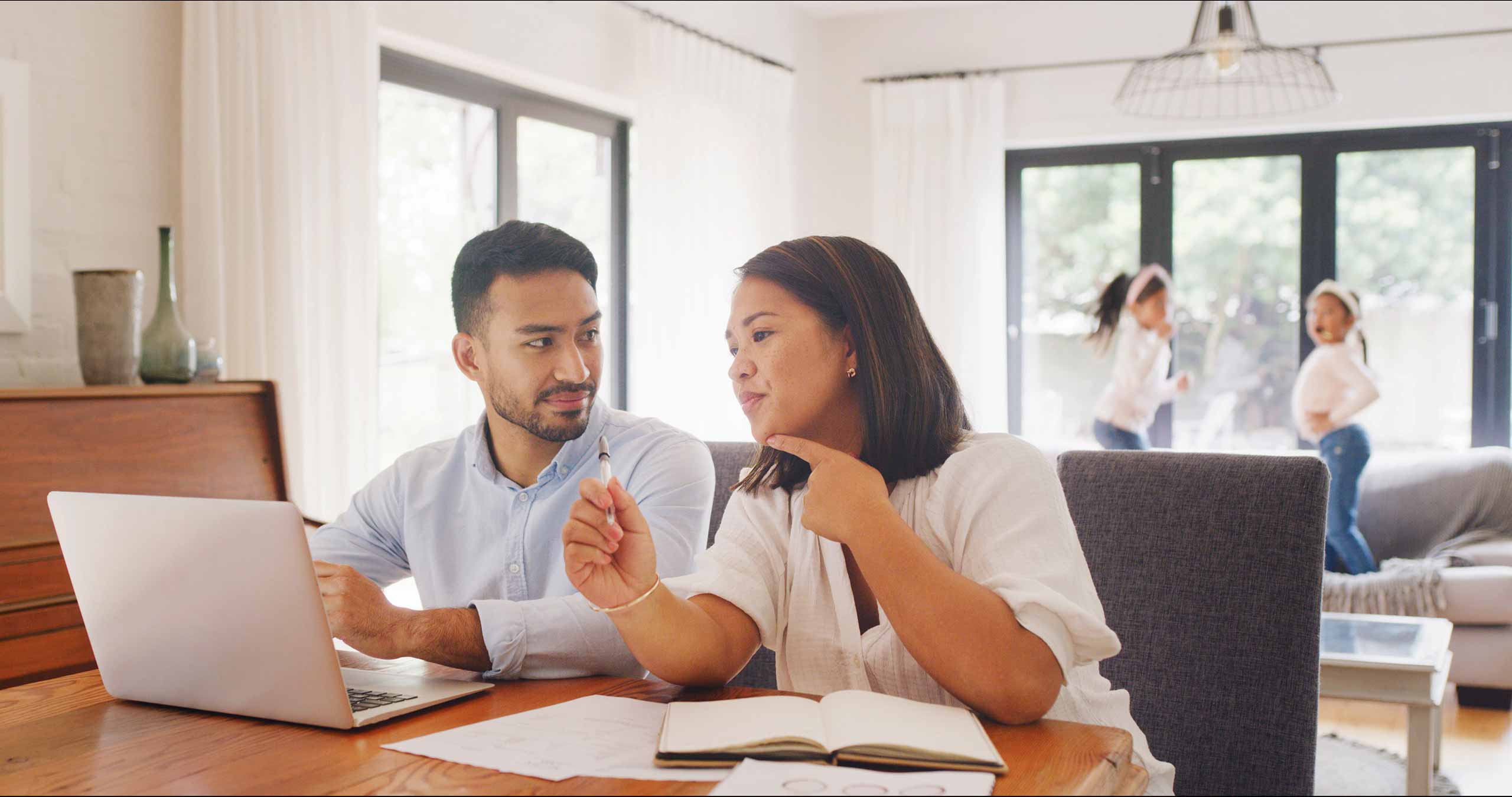 Actively employed couple using laptop for financial planning